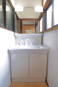 a bathroom with a sink and a mirror at 徒歩1分で行ける秘密のビーチ-ファミリー&釣り好きに大人気の宿 in Katsuura