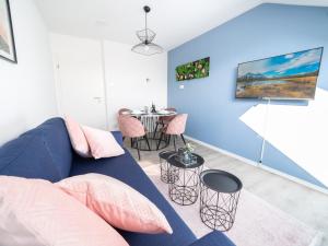 a living room with a blue couch and a table at Noble Suite - Parking - Workspace in Gießen