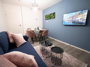 a living room with a blue couch and a table at Noble Suite - Parking - Workspace in Gießen