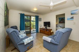 a living room with two chairs and a television at Magnetic North Apartment 1 in Arcadia