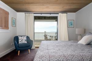 a bedroom with a bed and a chair and a window at FIVE STAR - Ruby Bay in Mapua