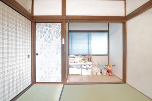 a room with a sliding glass door with a crib at ファミリー&釣り好きに大人気の宿-松部漁港まで徒歩1分 in Katsuura