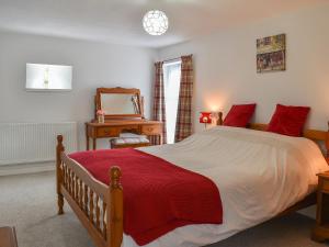 a bedroom with a large bed with a red blanket at Dove Cottage in South Hill