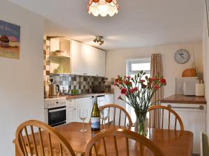 a kitchen with a wooden table with a vase of flowers at Dove Cottage in South Hill