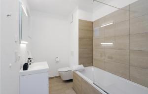 a bathroom with a tub and a toilet and a sink at Nice Apartment In Lembruchdümmer See in Lembruch