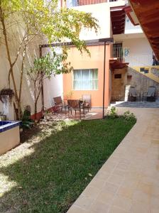 a patio with a table and chairs in a yard at Posada Antiguo Camino Real in Xalapa