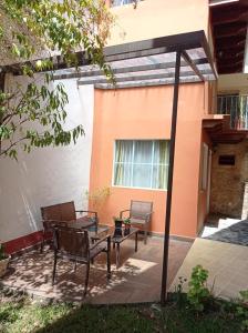 une terrasse avec une table et des chaises devant un bâtiment dans l'établissement Posada Antiguo Camino Real, à Xalapa