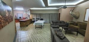 una sala de estar con un sofá y una mesa en Tranquillity Holiday Home, en Marloth Park