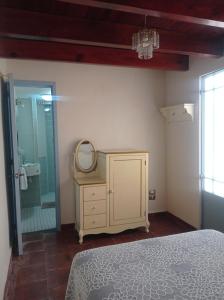 een slaapkamer met een spiegel, een dressoir en een douche bij Posada Antiguo Camino Real in Xalapa