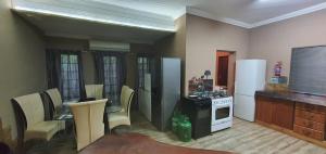 Una cocina con refrigerador y una mesa y sillas. en Tranquillity Holiday Home, en Marloth Park