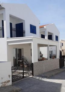 a white house with a black fence in front of it at Efterpis12 St. House in Paralimni