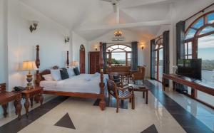 a bedroom with a bed and a living room with a tv at Ceylon Breeze in Kandy