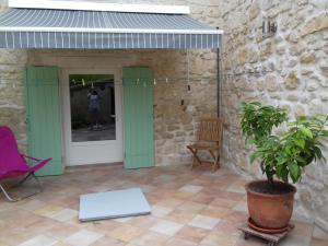 um pátio com portas verdes e uma planta em Chambre d'hôte Chez Josie em Beaucaire