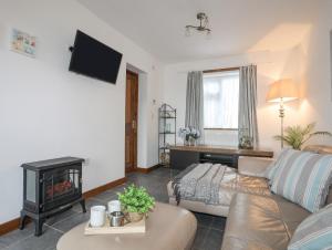 a living room with a couch and a fire place at Cottage in Pwllheli