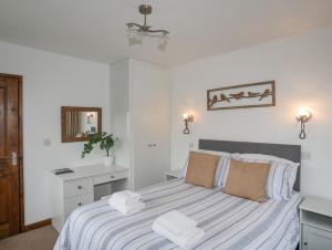 a bedroom with a bed with towels on it at Cottage in Pwllheli