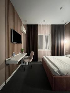 a hotel room with a bed and a desk at Hotel NOMAD in Aktobe