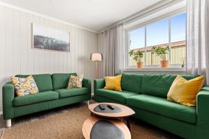 a living room with green couches and a table at Sagi 1 Privat Apartment in Hafslo