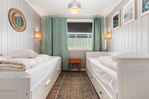 2 Betten in einem Zimmer mit grünen Vorhängen in der Unterkunft Sagi 1 Privat Apartment in Hafslo