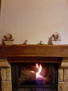 a brick fireplace with a fire in it at Le Gîte du Cheval Blanc in Fraize