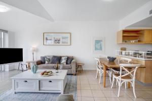 a living room with a couch and a table at The Lookout at Iluka Resort Apartments in Palm Beach