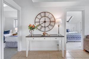 a room with a table and a large clock on the wall at The Lookout at Iluka Resort Apartments in Palm Beach