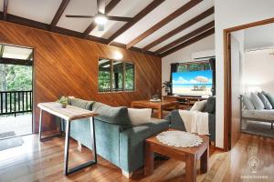 a living room with a couch and a tv at Bindi Treehouse - Elevated Pole Home in Freshwater