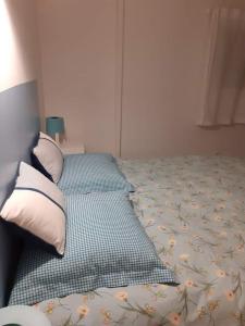 ein Bett mit zwei Kissen darauf in einem Schlafzimmer in der Unterkunft Le Gîte du Cheval Blanc in Fraize