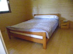 een bed in een kamer met een houten vloer bij Le Chalet du Chloris in Saint-Maxire