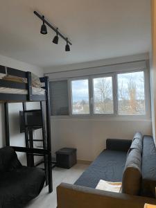a living room with a couch and a bunk bed at Appartement Ping-Pong proche gare Gagny in Gagny