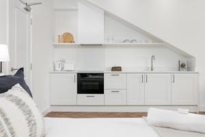 a white kitchen with white cabinets and a stove at 40 Renshaw Apartments in Liverpool