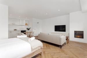 a white living room with a couch and a tv at 40 Renshaw Apartments in Liverpool