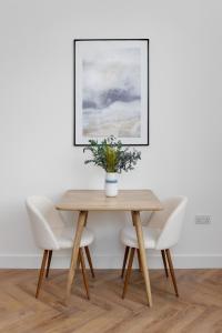a wooden table with chairs and a vase with flowers at 40 Renshaw Apartments in Liverpool