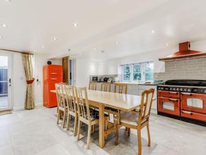 a kitchen with a wooden table and wooden chairs at Kings Barn in Weston under Lizard