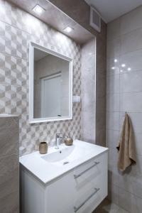 une salle de bain blanche avec un lavabo et un miroir dans l'établissement APARTAMENT KONOPNICKIEJ 11/23, à Karpacz