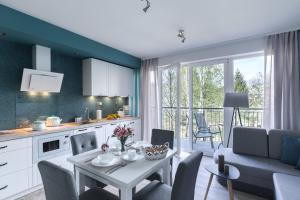 une cuisine et un salon avec une table, une cuisine et une salle à manger dans l'établissement APARTAMENT KONOPNICKIEJ 11/23, à Karpacz