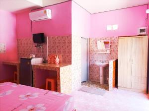 Habitación rosa con lavabo y baño. en Vimanmek Resort en Yasothon