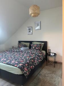 ein Schlafzimmer mit einem Bett mit einer Bettdecke und einem Tisch in der Unterkunft Le cocon de la belle liégeoise in Lüttich