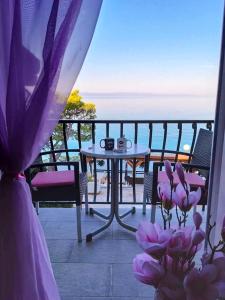 balcone con tavolo, sedie e vista sull'oceano di Apartmani Daša Tučepi a Tučepi