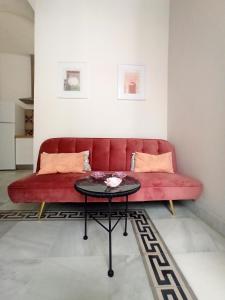 ヘレス・デ・ラ・フロンテーラにあるApartamentos La Higuera by VGHのリビングルーム(赤いソファ、テーブル付)