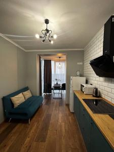 une cuisine avec un canapé bleu et un salon dans l'établissement Апартаменти в центрі ЖК Над Бугом, à Khmelnytsky
