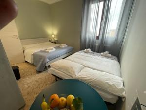 Habitación con 2 camas y mesa con fruta. en Dal Ciandri, en Pisa