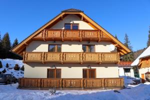 a house with a wooden balcony in the snow at Apartmán Linda Tále in Tale
