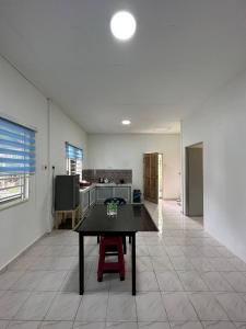 a kitchen with a table in the middle of a room at IBAI COTTAGE KUALA TERENGGANU (HOMESTAY) in Kuala Terengganu