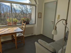 Zimmer mit einem Tisch, einem Stuhl und einem Fenster in der Unterkunft Casa Ai Portici in Gordola