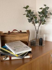 drewniany stół z książkami i wazon z rośliną w obiekcie Mountain Getaway - Ferienwohnung mit Sauna w mieście Albinen