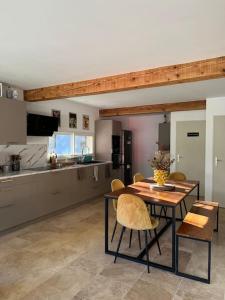 - une cuisine avec une table et des chaises dans la chambre dans l'établissement Maison 6 places, en plein cœur de l’Ariège, proche ski et nature, à Lesparrou