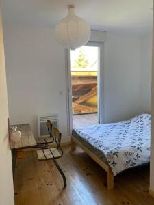 - une chambre avec un lit, une table et une fenêtre dans l'établissement Maison 6 places, en plein cœur de l’Ariège, proche ski et nature, à Lesparrou