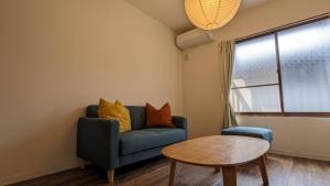 a living room with a blue couch and a table at Kiyomizu Donguri An in Kyoto