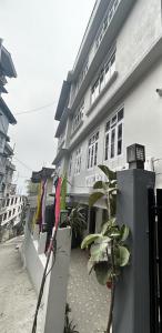 un edificio con una valla y plantas delante de él en The Better Inn en Gangtok