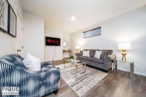a living room with two chairs and a couch at NEW Modern 2 Bedroom Suite, Complimentary Netflix, Sleeps 4 in Edmonton